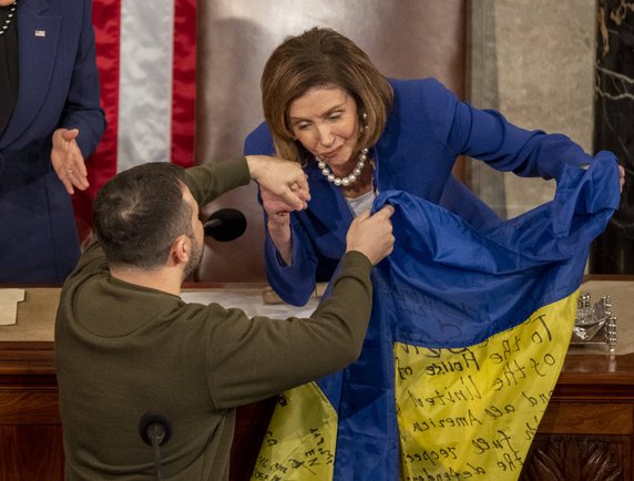 Wołodymyr Zełenski w amerykańskim Kongresie przekazuje flagę Ukrainy otrzymaną od żołnierzy w Bachmucie na ręce Nancy Pelosi. Była to pierwsza zagraniczna wizyta prezydenta Ukrainy od czasu wybuchu wojny. 21.12.2022 r.