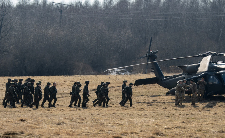 Żołnierze polscy (w ciemnych mundurach po lewej) i amerykańscy z 82. Dywizji Powietrznodesantowej ćwiczą załadunek helikopterów UH-60 Black Hawk w Birczy niedaleko Przemyśla, 15 marca 2022 r. 