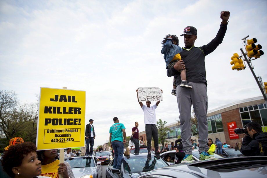 Demonstrators stand on top of vehicles at North and Pennsylvania avenues in Baltimore on May 1, 2015.