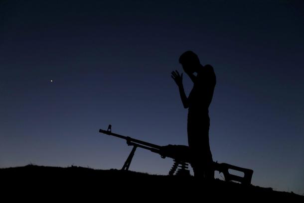 A Free Syrian Army fighter prays after eating his iftar (breaking fast) meal during the holy month o