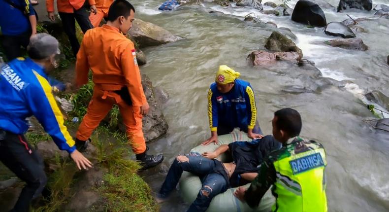 This picture released by Indonesia's national search and rescue agency (BASARNAS) shows rescue personnel retrieving a victim after a bus careered into a 150-metre deep ravine and ended up in a river, near Perahu Dipo village in South Sumatra