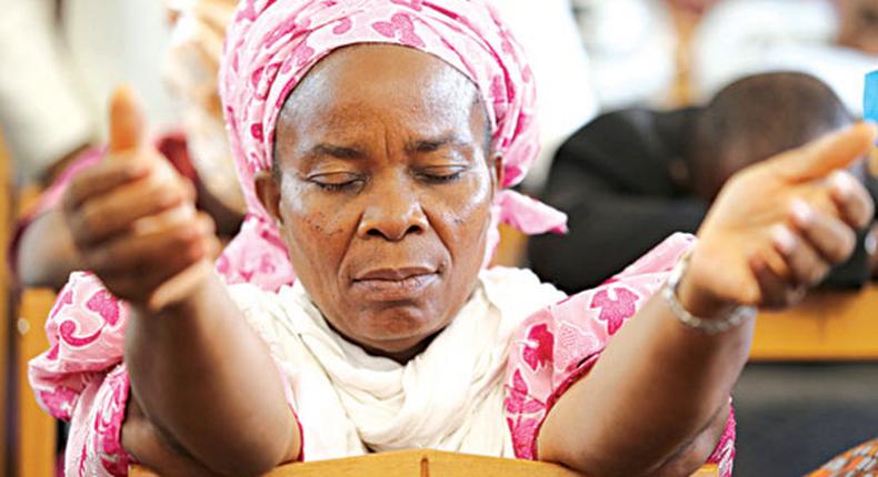 A woman praying on her knees [The Guardian Nigeria]