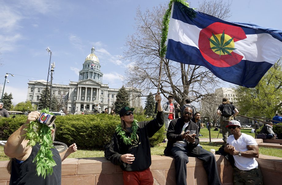 A man waves a Colorado flag with a marijuana leaf on it at Denver's annual 4/20 marijuana rally in front of the state capitol building on April 20, 2015.