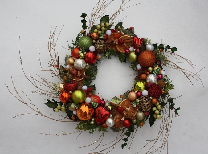 Kolorowy wianek bożonarodzeniowy z bombkami, suszonymi owocami, gałązkami i cynamonem. Autorka: Marta Jarosińska-Mańka
