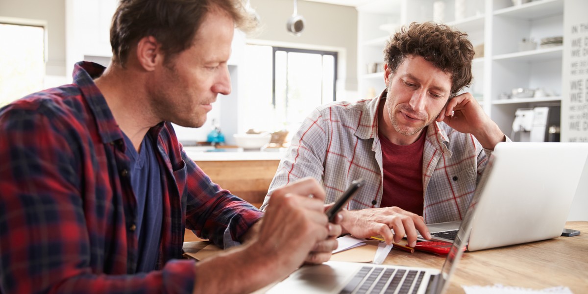 Mature Hispanic Man Using Laptop On Desk At Home