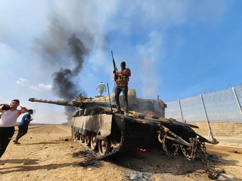 Bojownicy Hamasu przy zniszczonym izraelskim czołgu Merkawa obok granicy ze Strefą Gazy