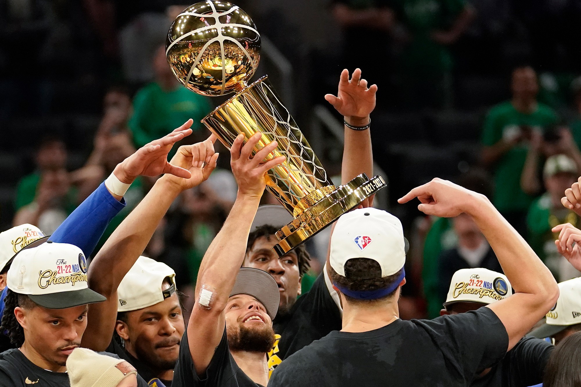 Basketbalista tímu Golden State Warriors Stephen Curry s trofejou Larryho O'Briena oslavuje víťazstvo v NBA po výhre nad Bostonom Celtics v šiestom zápase finálovej série zámorskej basketbalovej NBA.