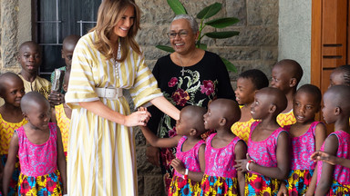 Melania Trump w długiej sukience w żółto-białe pasy i baletkach w Afryce