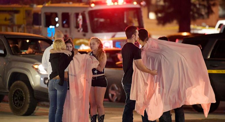 People comfort each other near the scene of the bar shooting in Thousand Oaks, California.