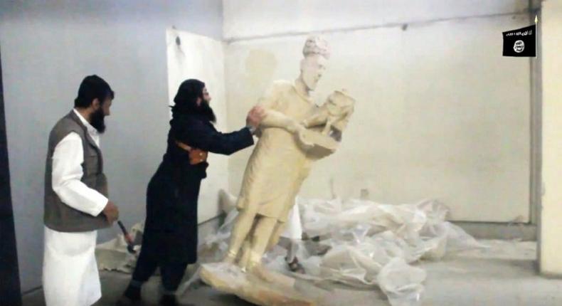 Image grab taken from a video released by the Media Office of the Nineveh branch of the Islamic State (IS) Group on February 26, 2015 allegedly showing an IS militant pushing a statue inside the Mosul museum