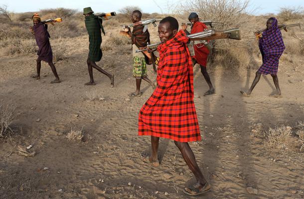 Turkana tribesmen walk with guns in order to protect their cattle from rival Pokot and Samburu tribe