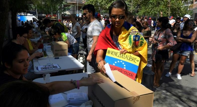 A Venezuelan resident in Barcelona casts her ballot during a symbolic plebiscite on president Maduro's project of a future constituent assembly, called by the Venezuelan opposition and held in Barcelona on July 16, 2017