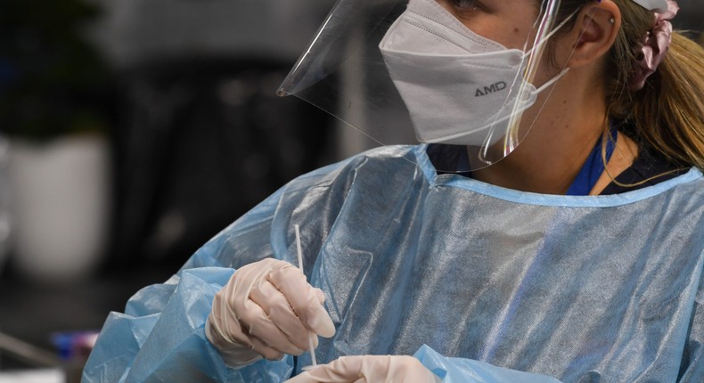 A health staff member prepares a COVID-19 test at the Histopath Diagnostic Specialists pre-departure area at Sydney International Airport on November 28, 2021.