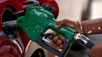 A worker holds a nozzle to pump petrol into a vehicle at a fuel station [Reuters/Francis Mascarenhas]