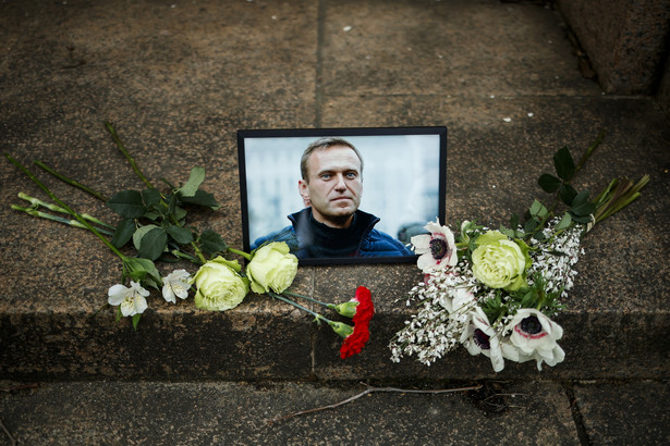 Portret Nawalnego otoczony kwiatami przed rosyjską ambasadą w Paryżu