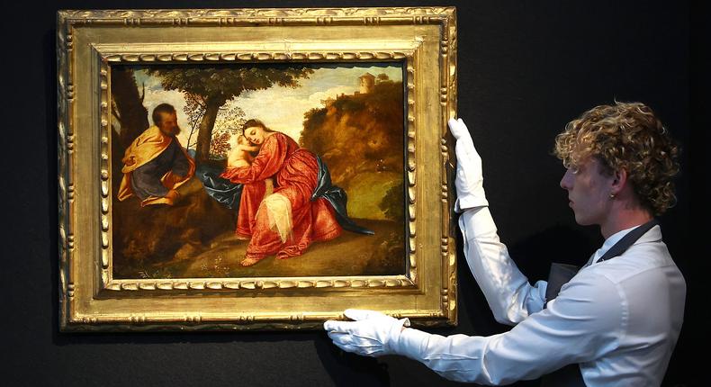 A Christie's curator holds Titian's Rest on the Flight into Egypt.Peter Nicholls/Getty Images