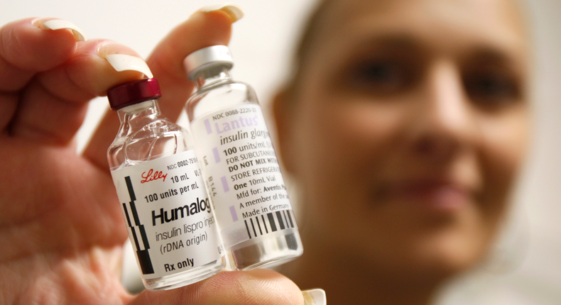 A Type 1 diabetes patient holds up bottles of insulin.