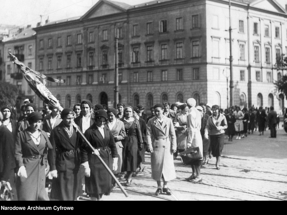 Grupa dziewcząt ze sztandarem szkolnym po nabożeństwie na ul. Krakowskie Przedmieście. W tle kamienica przy ul. Krakowskie Przedmieście 36. Zdjęcie pochodzi z 1933 r.