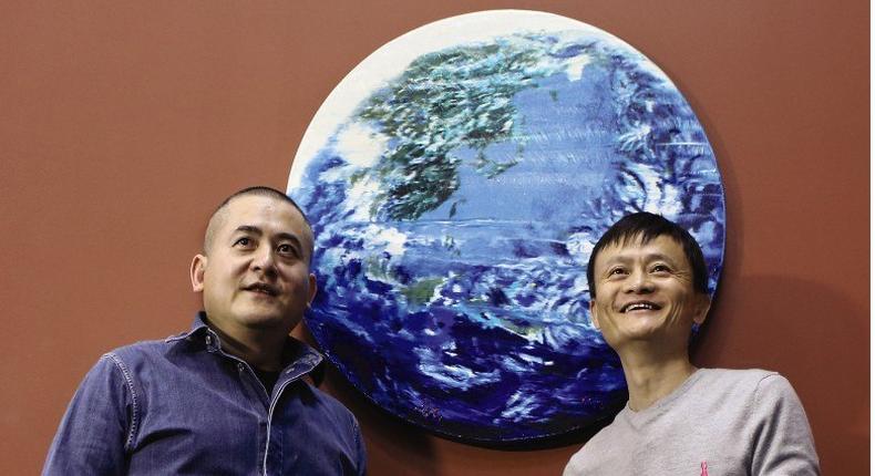 Zeng Fanzhi and Jack Ma strike a pose with their Earth painting which sold for $5.4 million at a Sotheby's auction