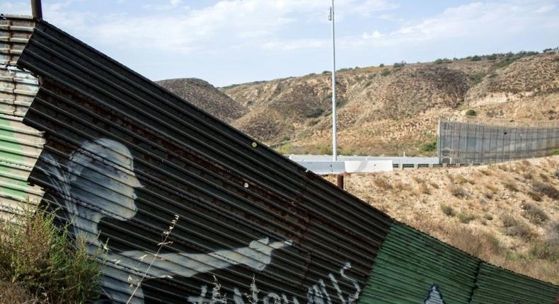 Partial view of the US-Mexico border wall painted by members of the Brotherhood Mural organization in Tijuana, Mexico