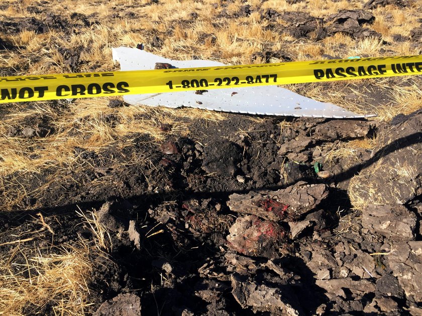 A civilian takes a photograph of the wreckage at the scene of the Ethiopian Airlines Flight ET 302 p