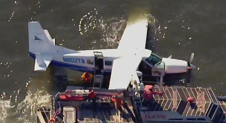 Rescuers tend to a disabled seaplane on the East River in New York.