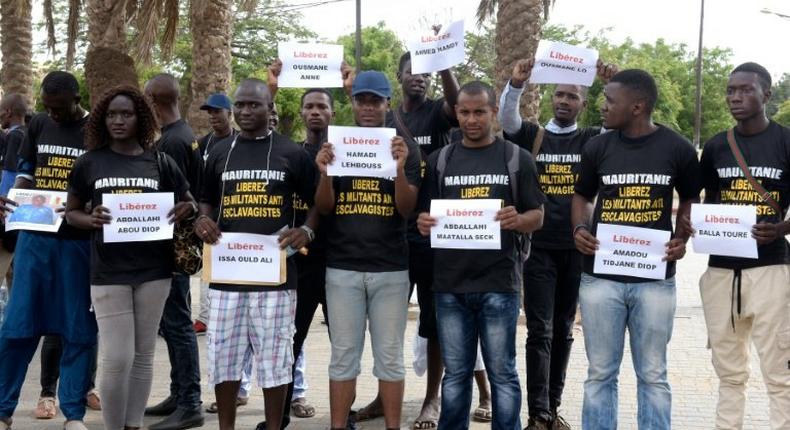 Anti-slavery activists demonstrate in Dakar against the imprisonement of fellow activists in Mauritania, holding cards with the names of those detained