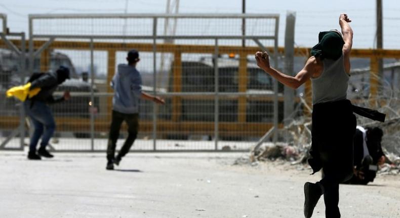 Palestinian protesters hurl stones towards Israeli security forces during clashes following a demonstration in solidarity with hunger-striking Palestinian prisoners, in front of Ofer prison in the West Bank, on April 20, 2017