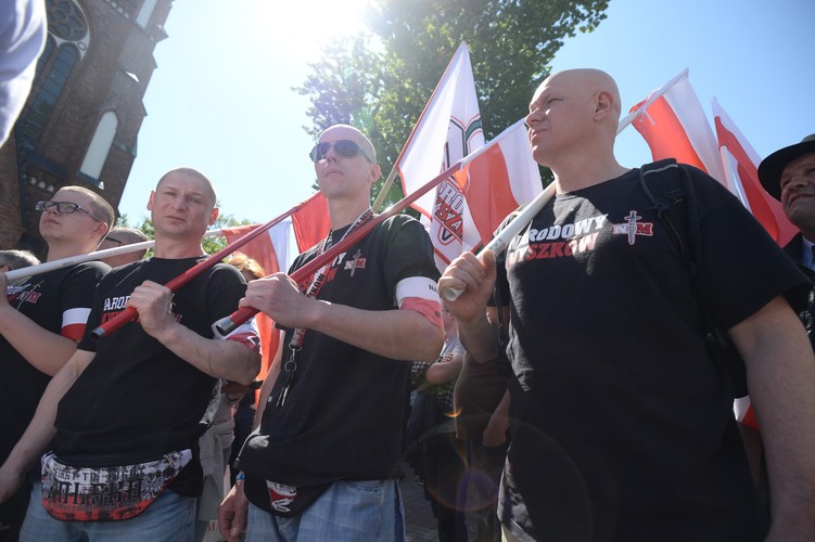 Uczestnicy manifestacji mają biało-czerwone flagi i opaski, gdzieniegdzie pojawiają się też flagi ONR, a na jednym z transparentów napisano: 