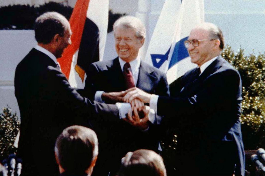 3. Anwar Sadat, Menachem Begin, and Jimmy Carter engage in a three way handshake to mark the end of the signing of the Israeli-Egyptian peace treaty.