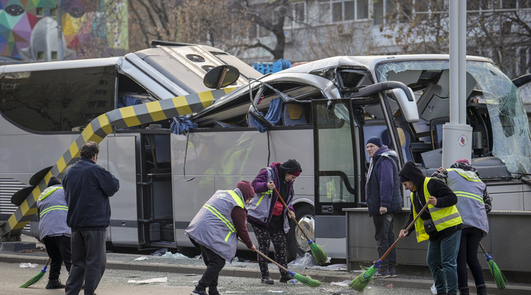 Negyvenhét görög utast szállító busz roncsa mellett takarítják fel a törmeléket városi alkalmazottak Bukarestben / Fotó: MTI/AP/Vadim Ghirda 