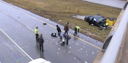 Pieniądze zasypały autostradę! Policjant zamiatał je szczotką