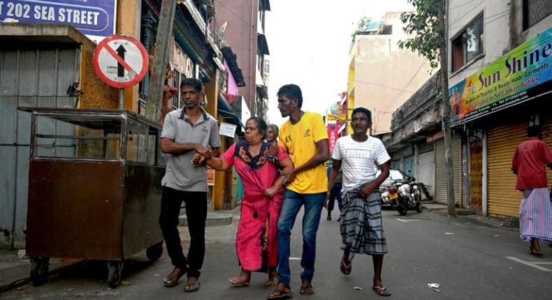 Colombo residents flee their home in fear of a car bomb near St. Anthony's Shrine in the wake of coordinated attacks