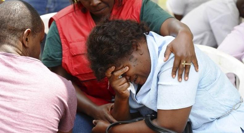A relative is assisted by Red Cross staff as bodies of the students killed in Thursday's attack arrive at the Chiromo Mortuary in Nairobi on Friday. 