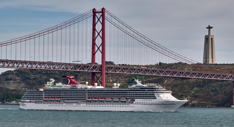 Carnival Pride, a Spirit-class cruise ship operated by Carnival Cruise Line, sails across the Tagus River.