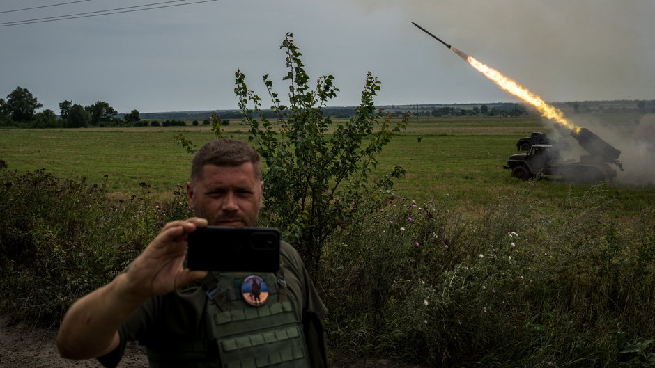 Ukraiński żołnierz robi sobie zdjęcie z wyrzutnią Grad. Linia frontu pod Donieckiem, 12 sierpnia 2022 r.