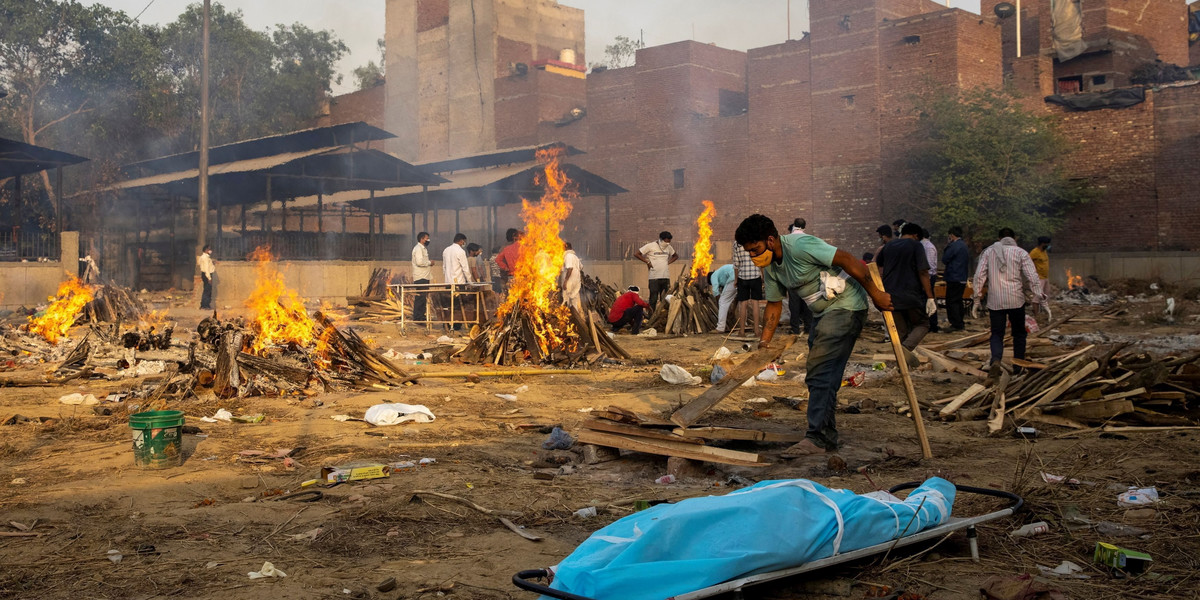 A relative lights the pyre for a COVID-19 victim at a crematorium ground in New Delhi