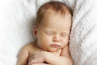 newborn baby sleeping on a white blanket