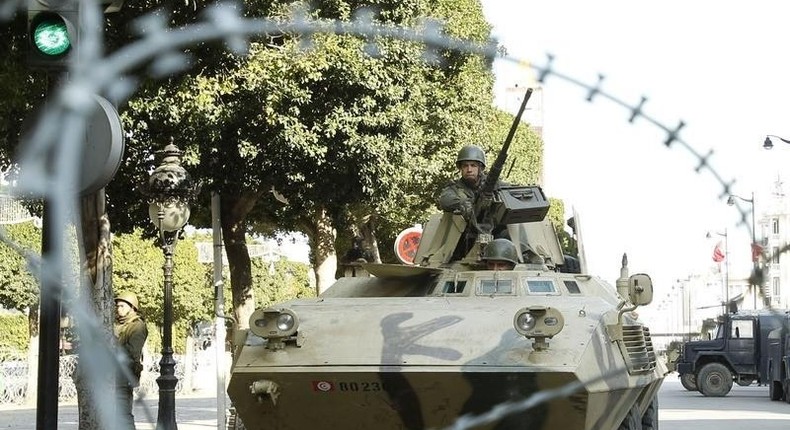 An army soldier stands guard behind a wire fence cordon outside the interior minister's office in Tunis February 7, 2011. REUTERS/Zoubier Souissi