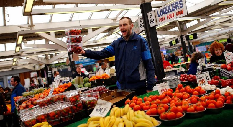 A worker sells strawberries on a market stall in Leicester, England