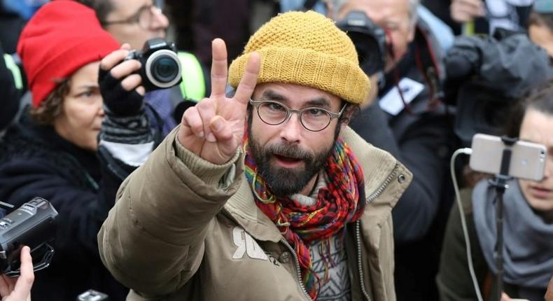 French farmer Cedric Herrou flashes the victory sign as he leaves the Nice courthouse on February 10, 2017