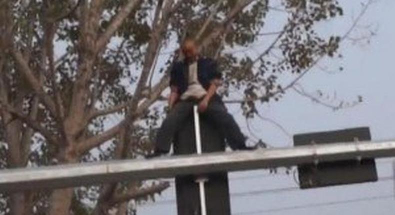 Drunk man shows off martial arts skills on a traffic light pole