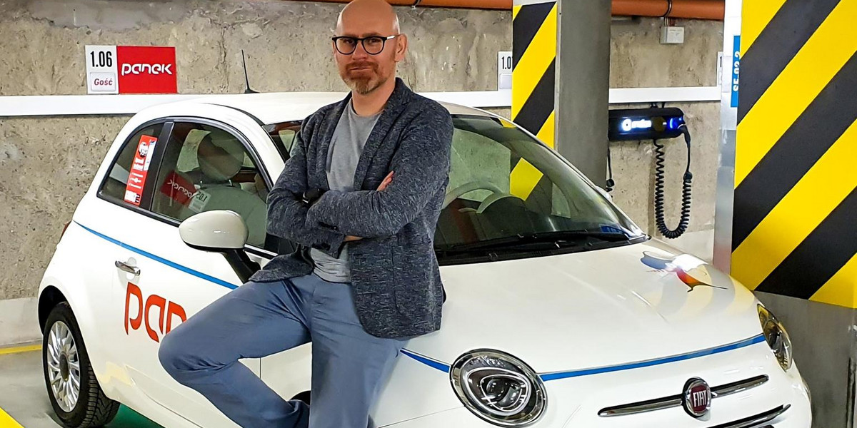 Maciej Panek przy samochodzie w barwach swojej firmy