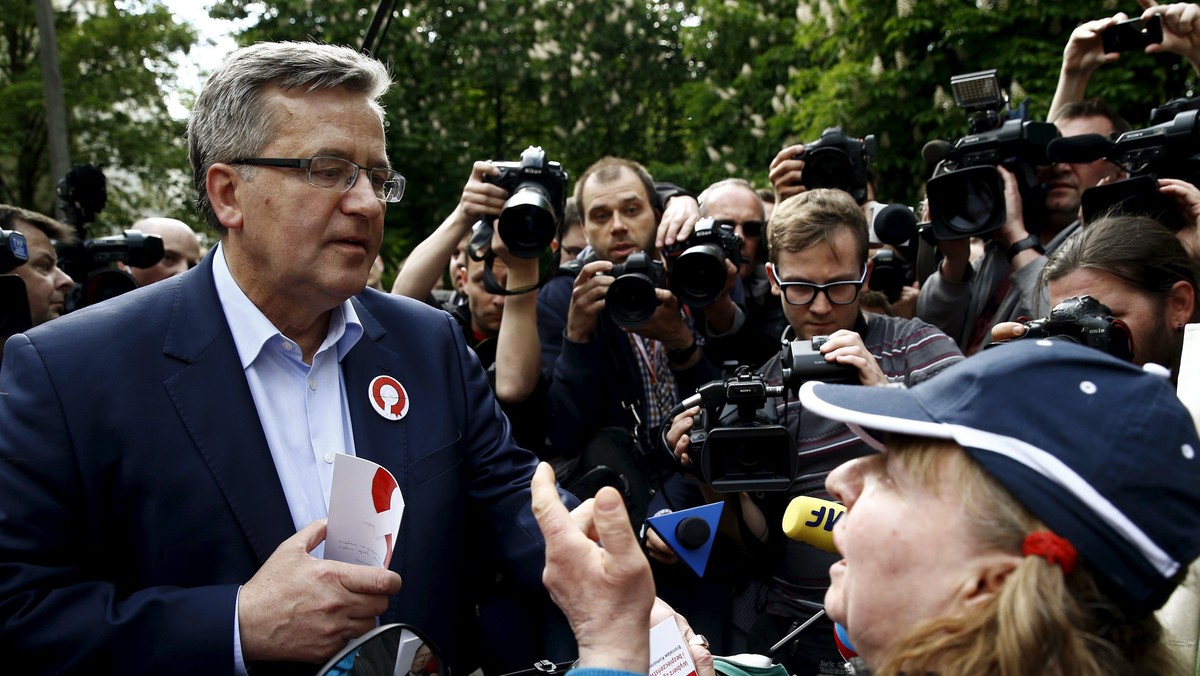 Poland's President Bronislaw Komorowski talks with a woman during his election campaign in Warsaw