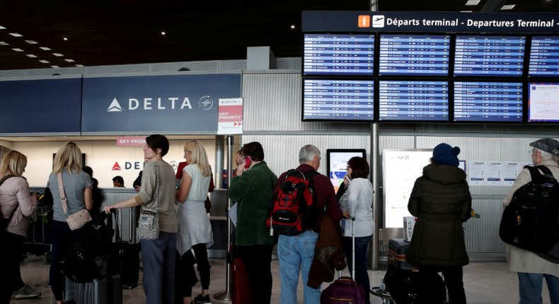 FILE PHOTO: People line up at the Delta Air Lines ticketing desk inside Terminal 2E at Paris Charles de Gaulle airport in Roissy, after the U.S. banned travel from Europe, as France grapples with an outbreak of coronavirus disease (COVID-19), March 12, 2020.  REUTERS/Benoit Tessier/File Photo