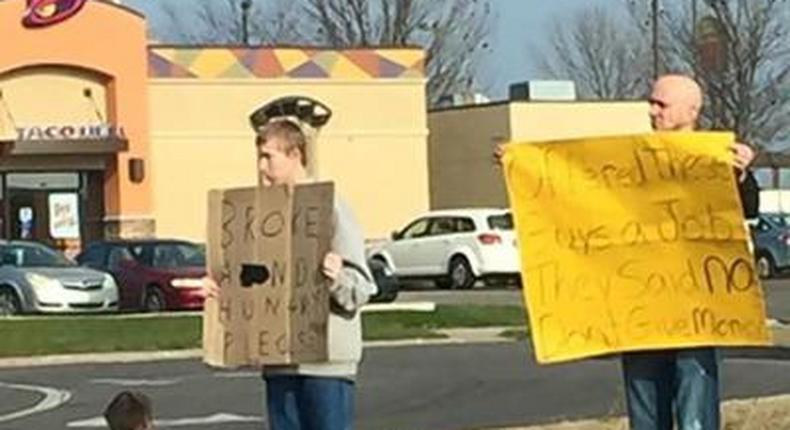 Mike Pothoff beside the panhandlers holding his sign
