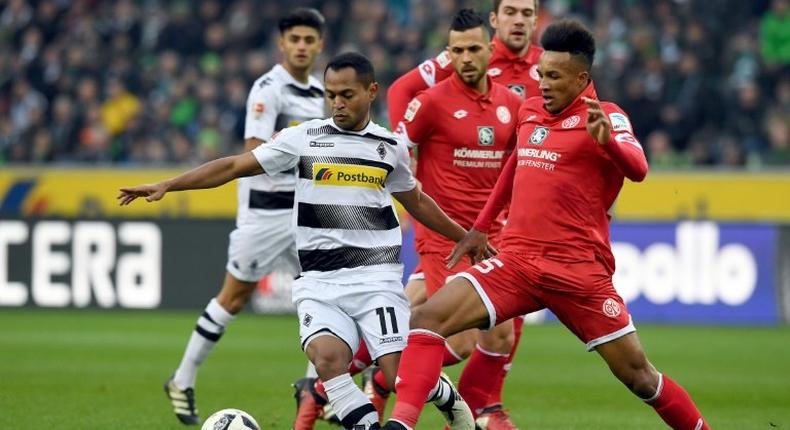 Moenchengladbach's forward Raffael (L) and Mainz' midfielder Jean Philippe Gbamin fight for the ball during their Bundesliga match in Moenchengladbach, on December 11, 2016