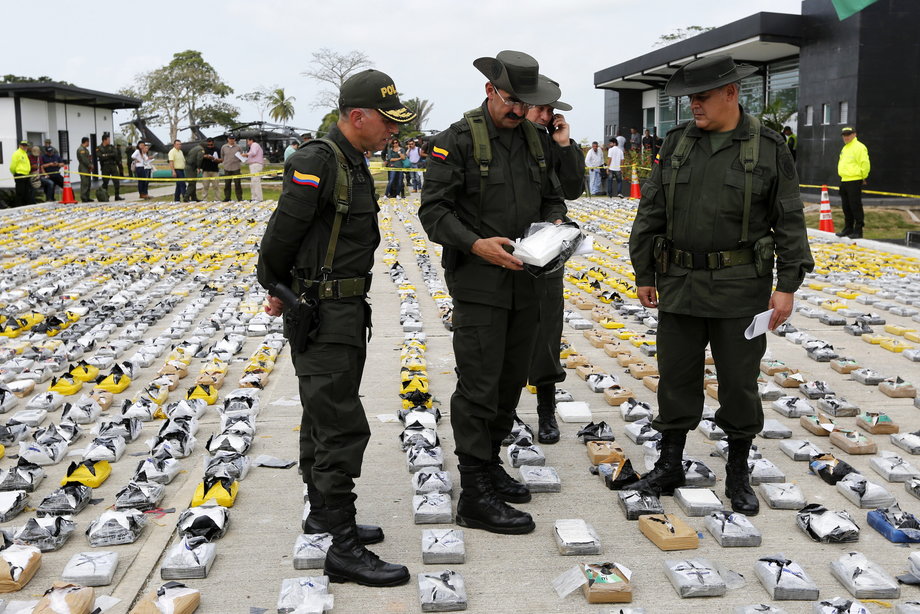 Colombian police officers examine confiscated packs of cocaine at the police base in Necocli, February 24, 2015.