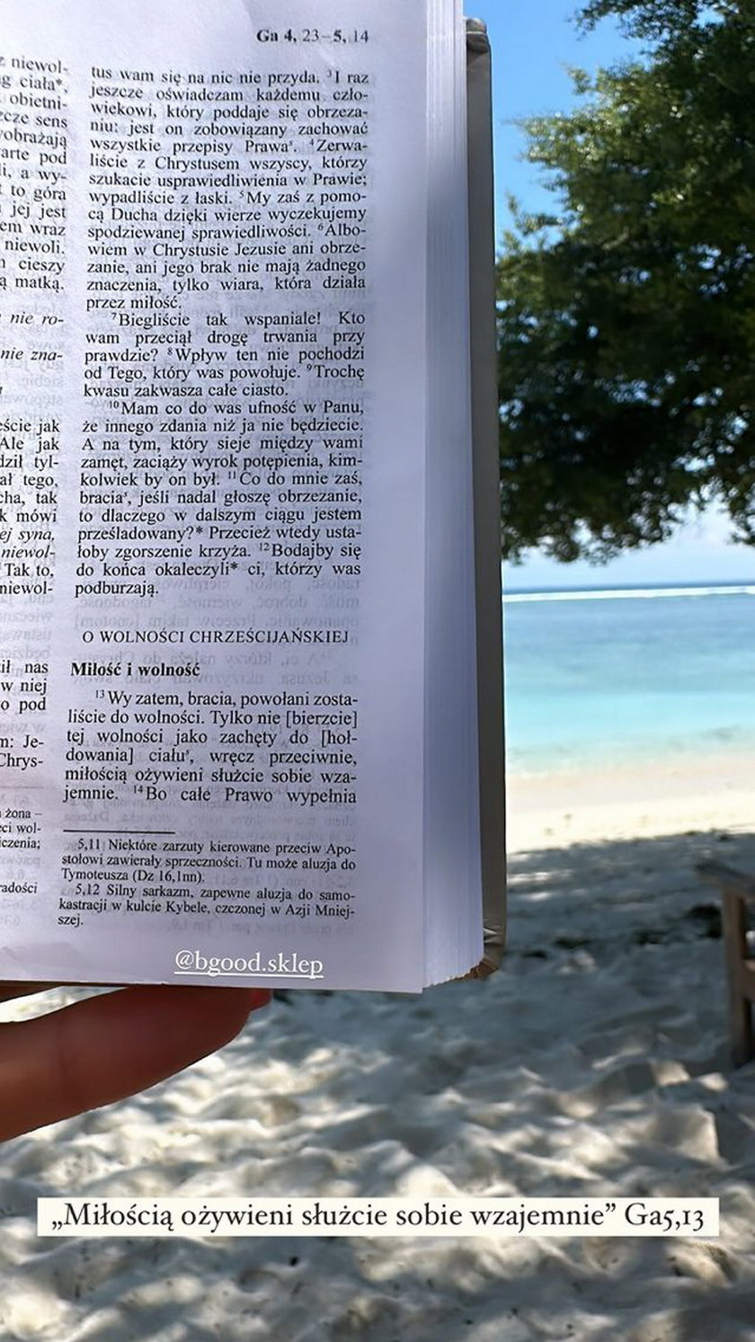 Magdalena Czech czyta Biblię na plaży.