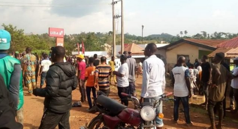 Residents of the community gather around the bank after the robbery incident. (TheCable)